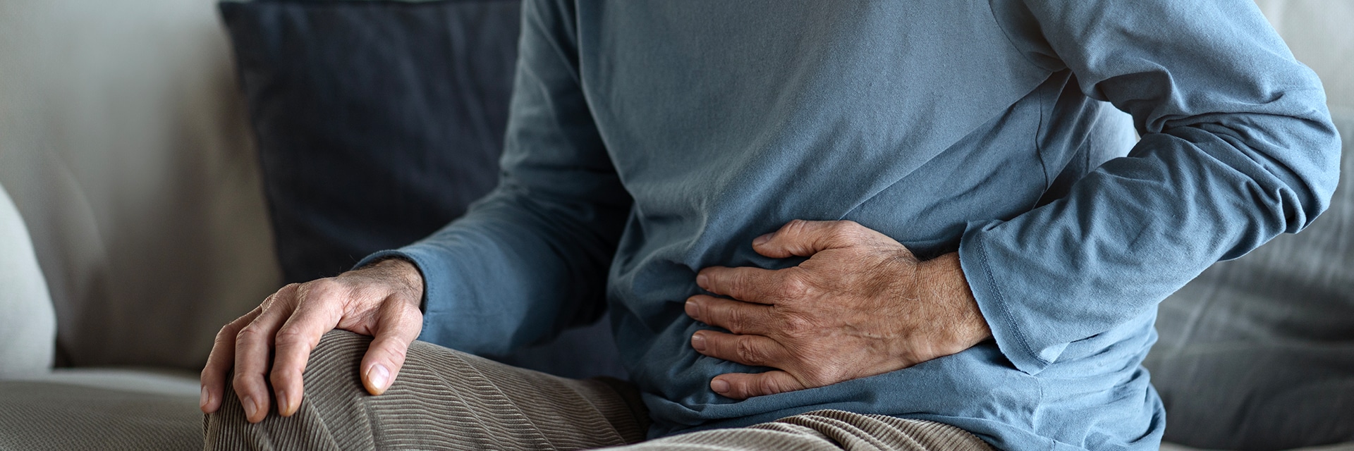 older man holding stomach