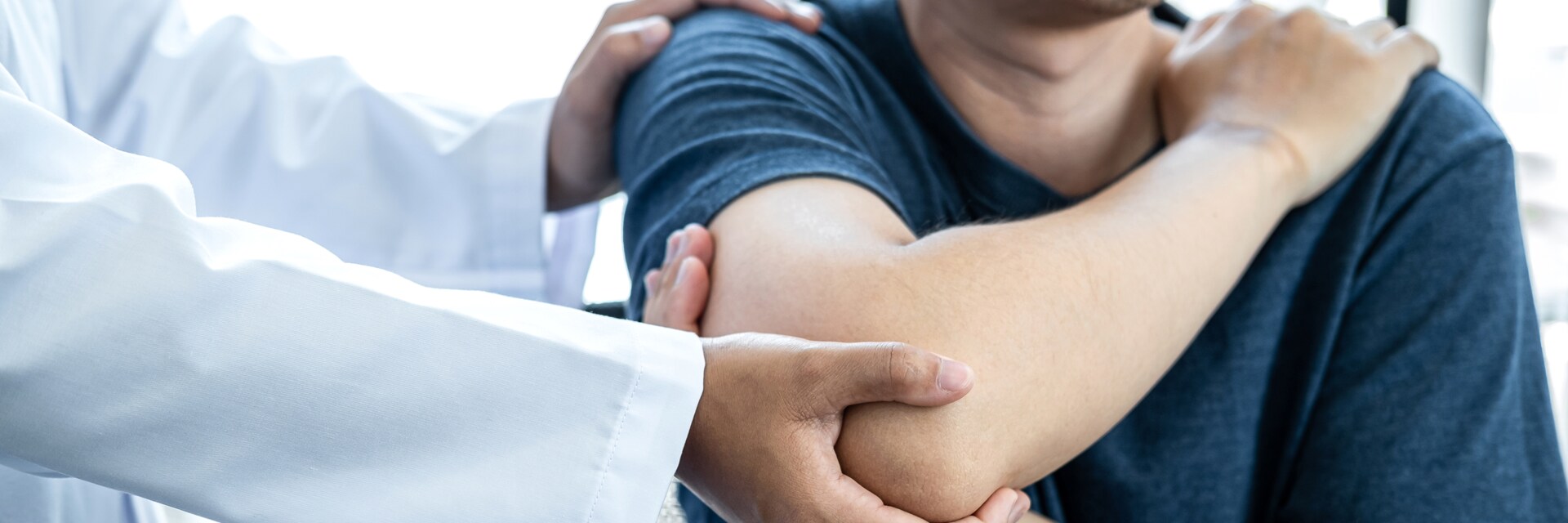 doctor with patient checking elbow