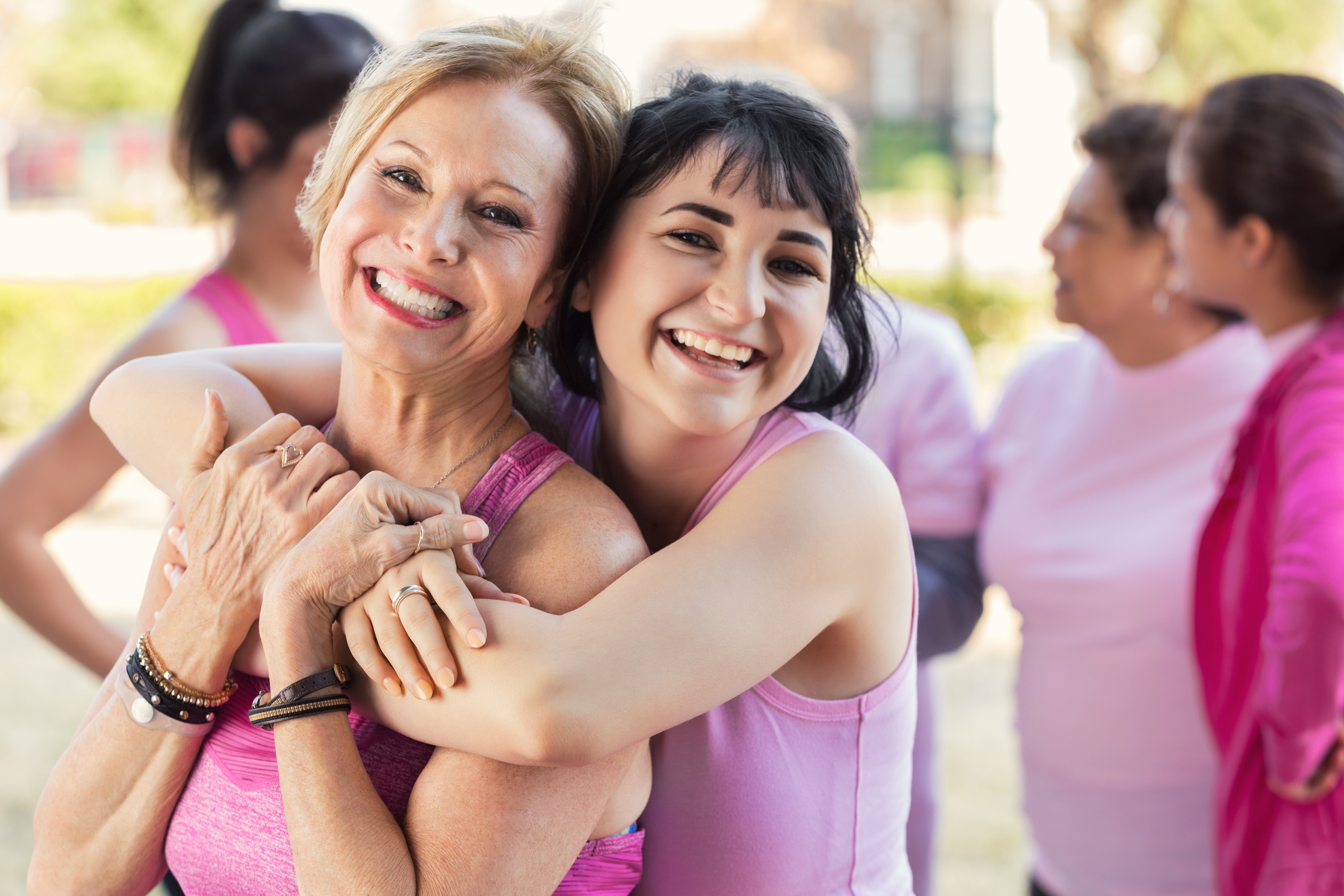 Two women hugging and are wearing pink