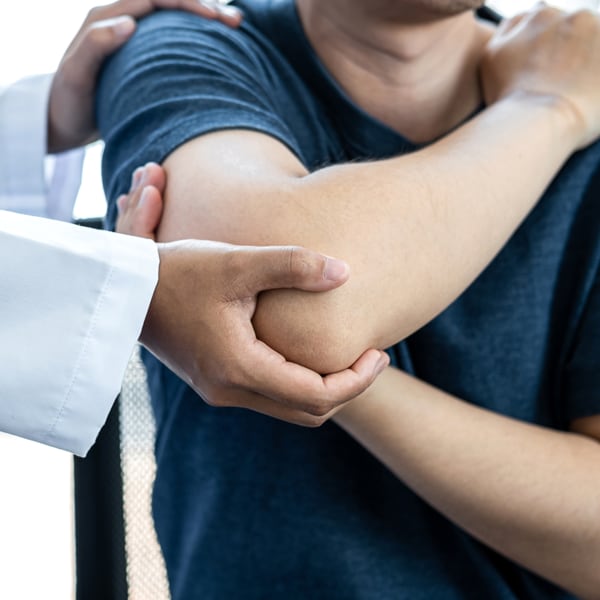 doctor with patient checking elbow